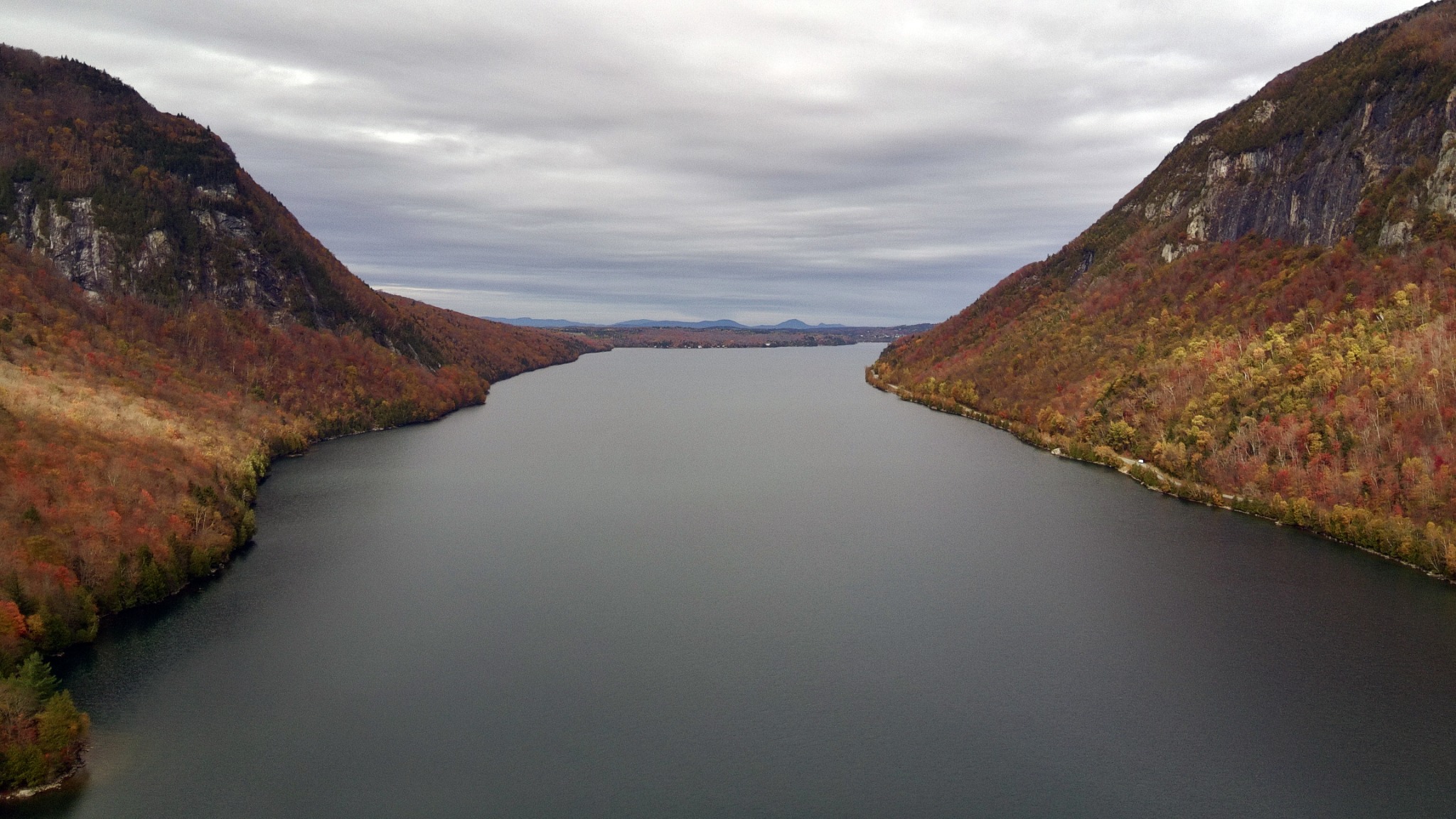Aerial view of Lake Willoughby between autumn mountain cliffs