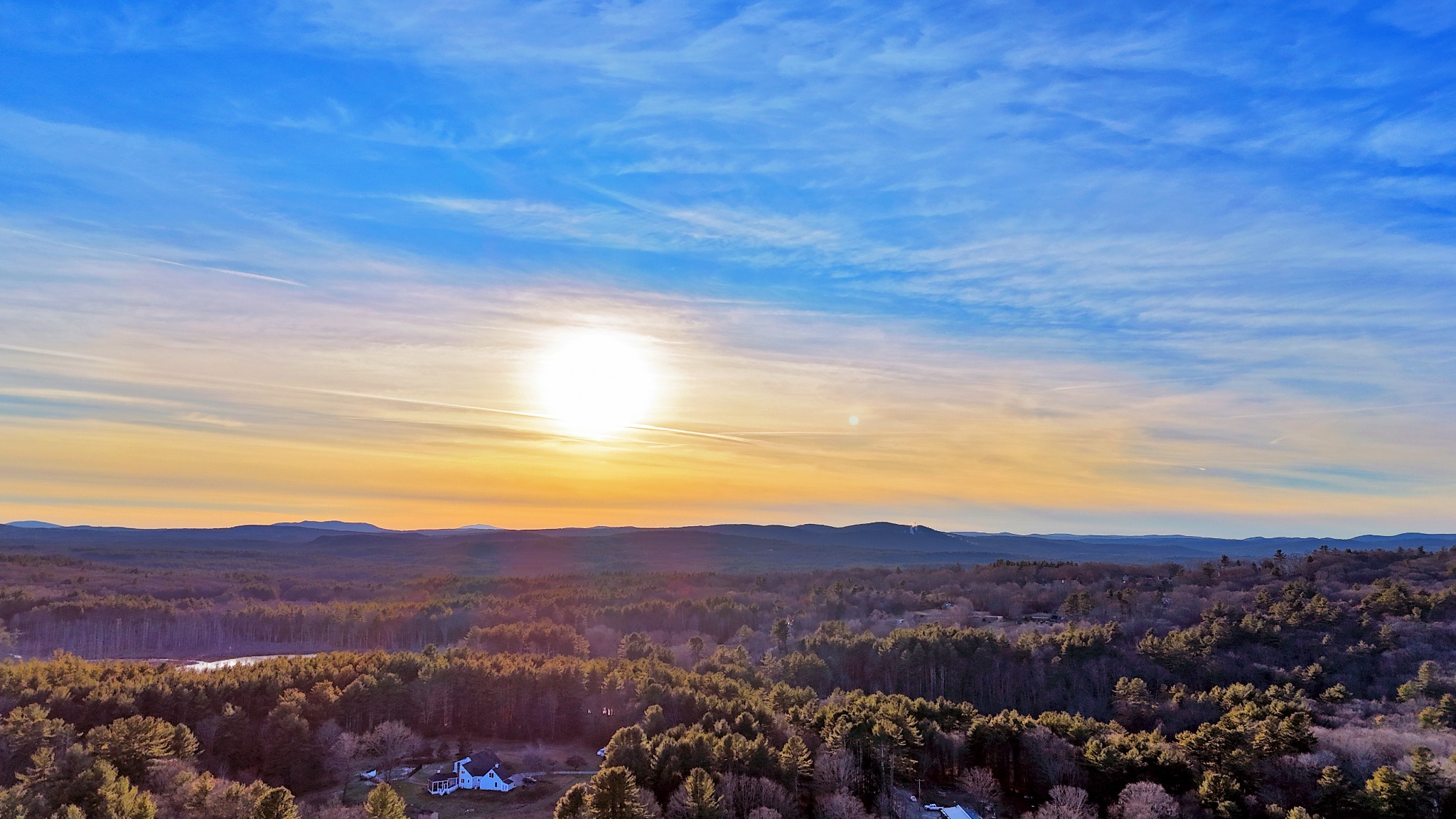 Aerial sunset over rolling New England forest and hills