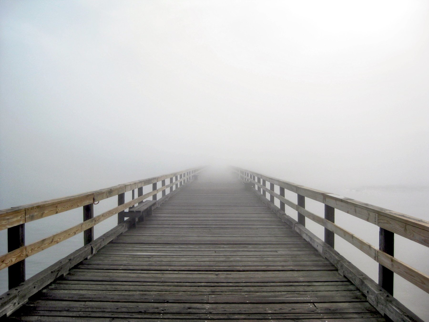 Foggy wooden pier disappearing into mist in Kittery Maine